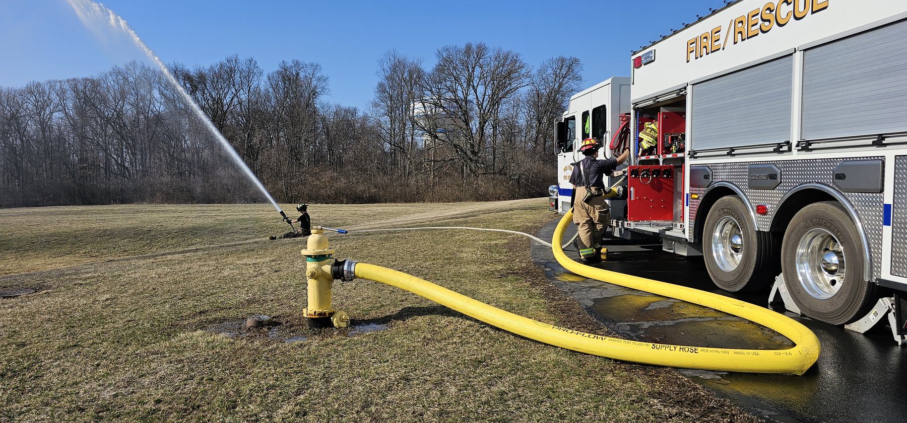 Crews flowing a supply line from a hydrant during pump training