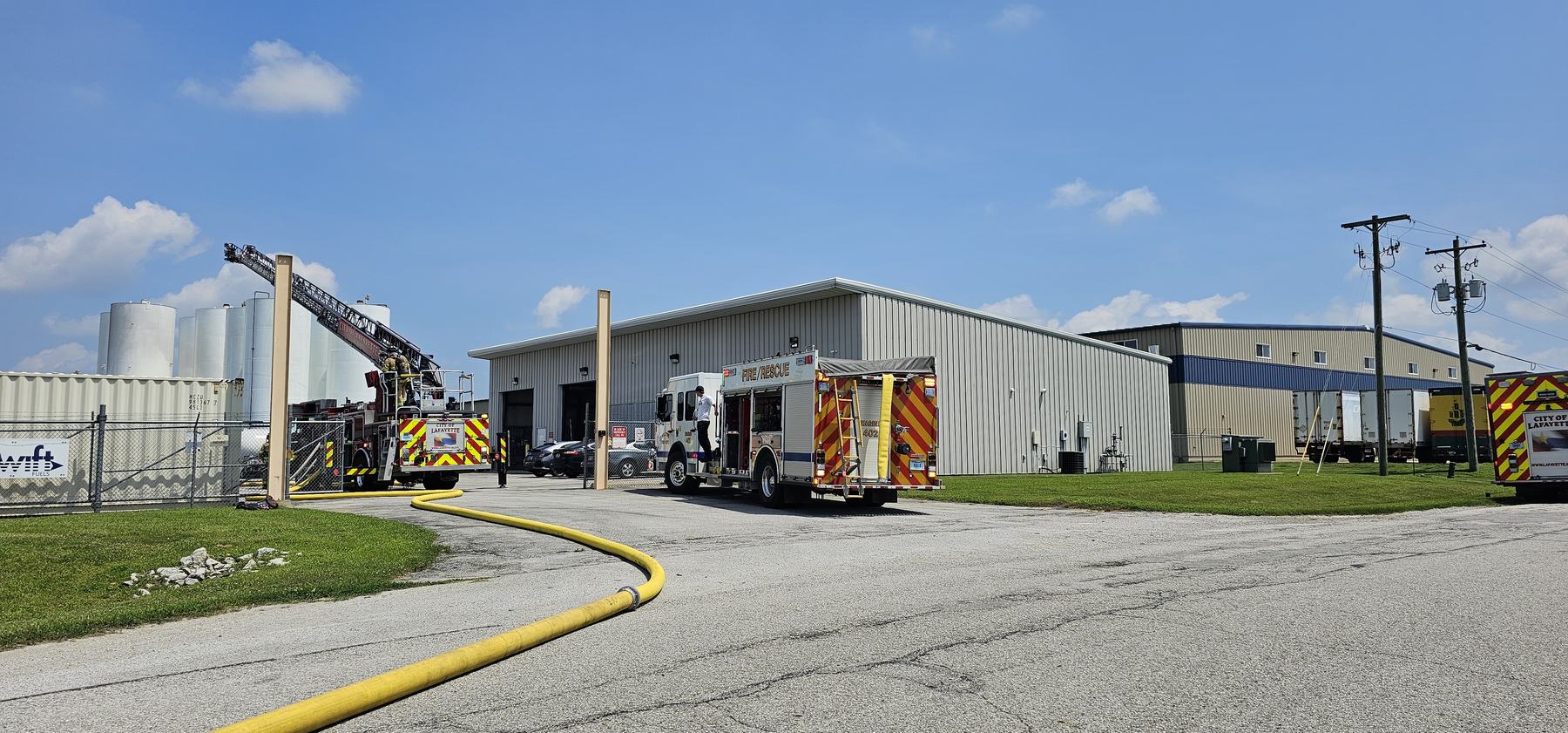 Aerial ladder and engines outside an industrial building