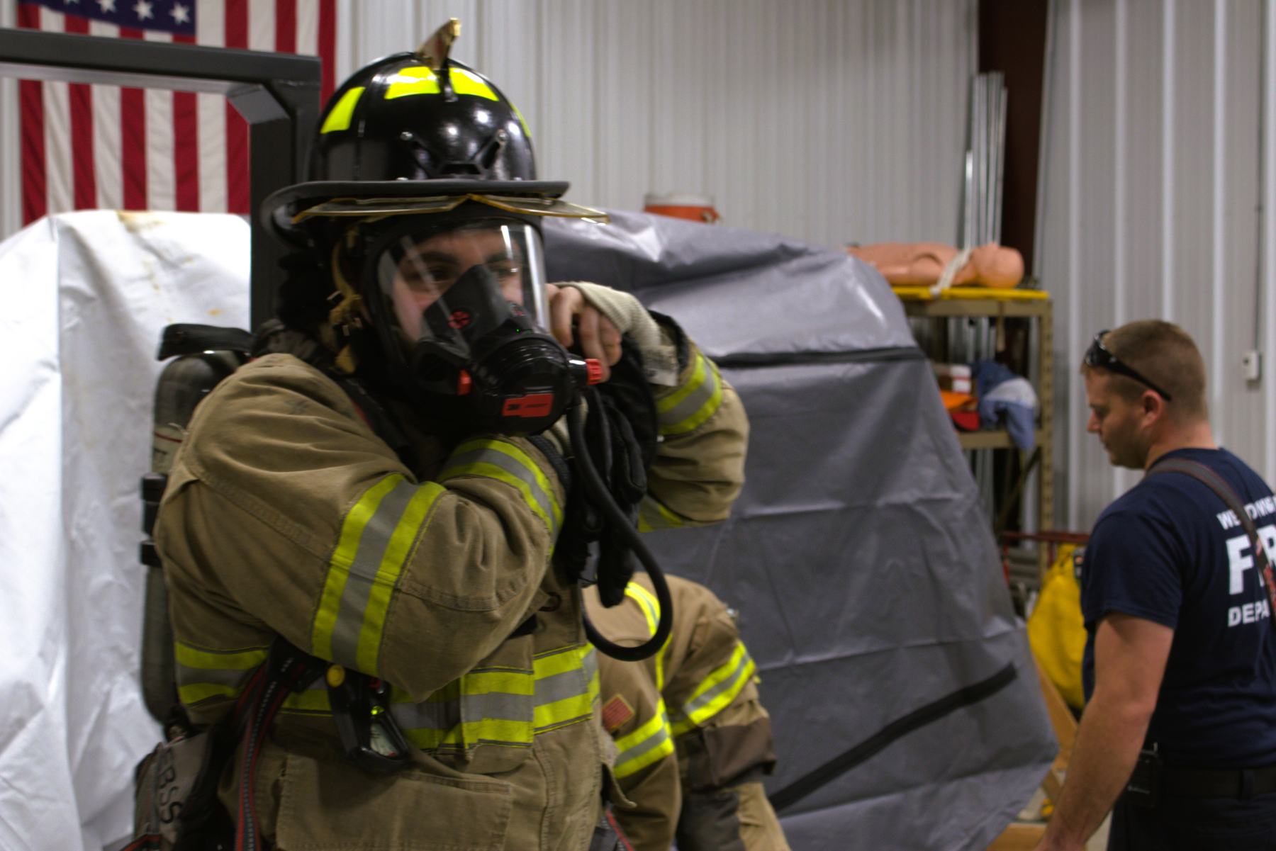Firefighter in full gear inside a dim training maze