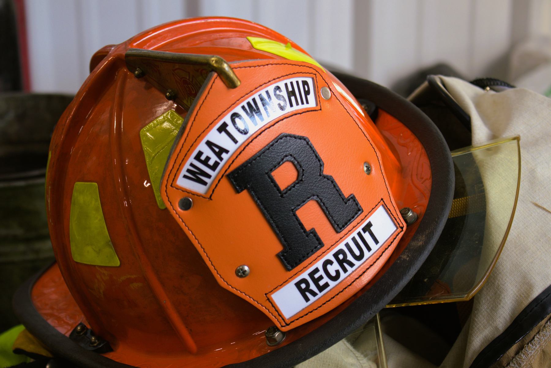 Orange fire helmet with a Wea Township Recruit shield
