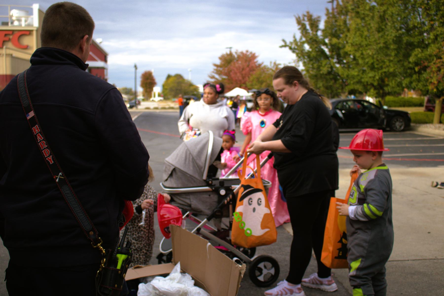 Firefighter with families at the trunk-or-treat