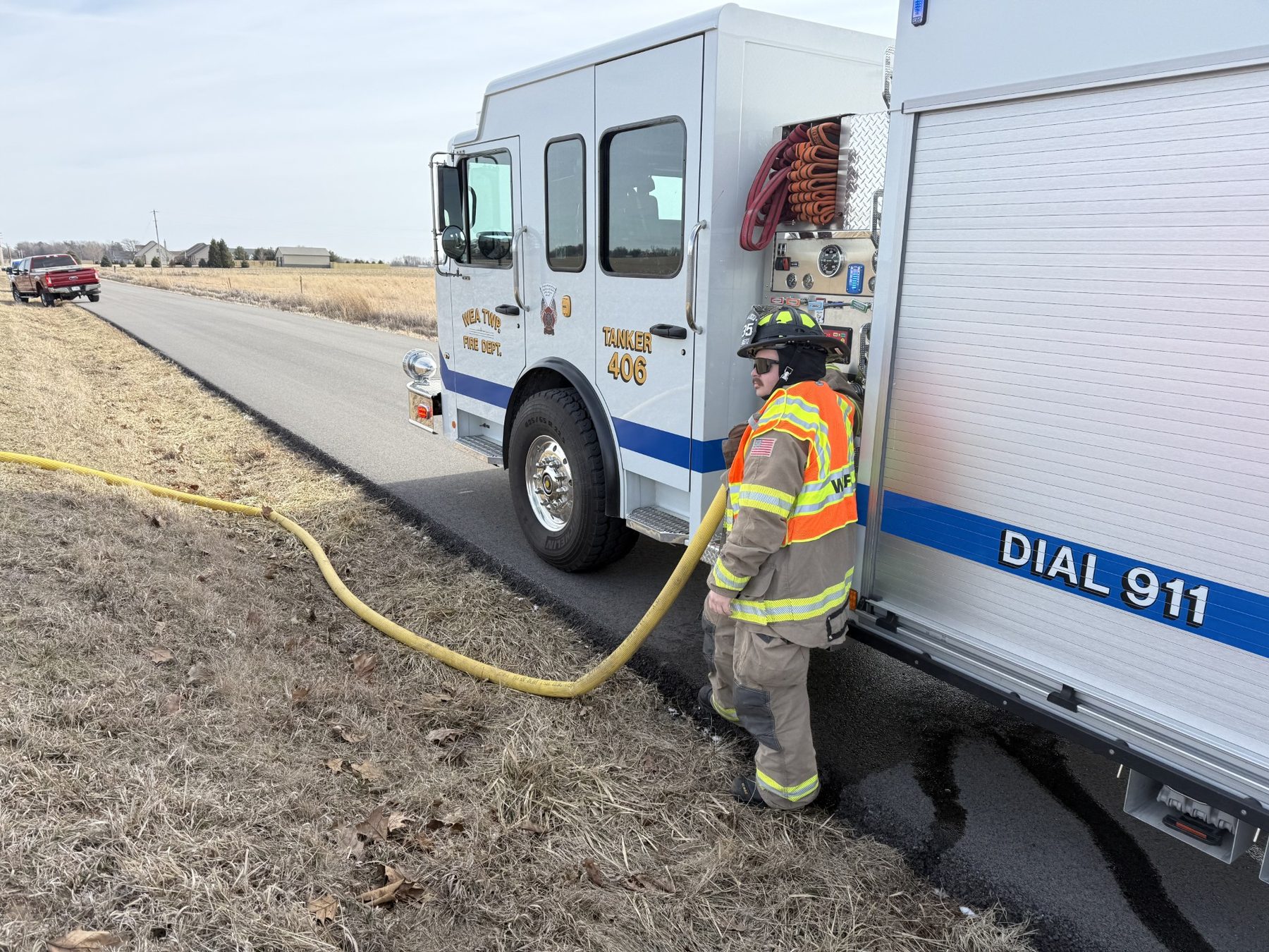 Firefighter working a supply line beside the tanker